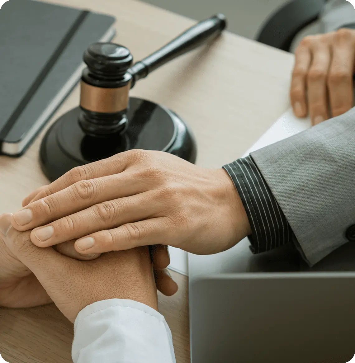 Hands clasped on desk near gavel.