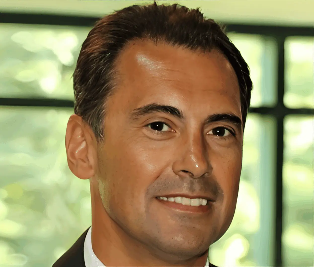 Smiling man in a suit indoors.